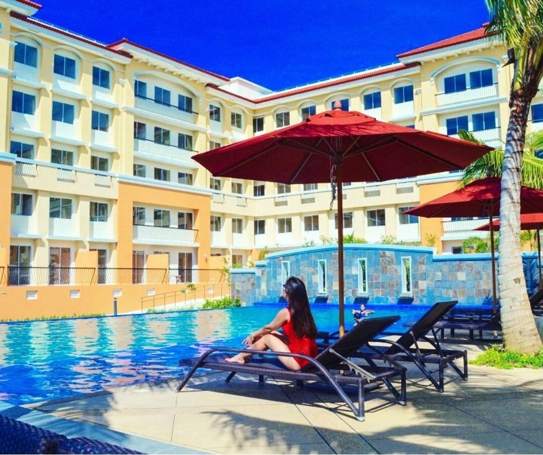 Kara's Condotel exterior with pool and palm trees